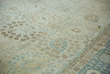 Low pile texture showing the detailed palmette patterns on a distressed vintage Tabriz carpet.