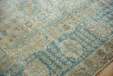 Decorative wear and texture of a distressed Tabriz rug in dusty blue and sand.