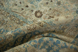 The distressed, low pile of a vintage Tabriz carpet with time-softened blue and brown floral details.