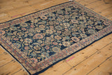 Meandering vine and floral border with a blue Herati motif field on a vintage Lilihan rug.