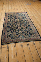 Vintage Lilihan rug corner with fringe, dusty blush floral border, and navy Herati field.
