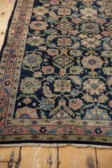 Vintage Fine Lilihan rug's fringe, dusty blush meandering vine border, and blue Herati field.