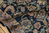 Folded close-up of vintage Lilihan rug's dense Herati motif in navy, blush, and sand.