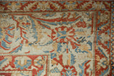 Corner detail of a distressed Persian Bakhtiari showing scrolling arabesques and worn knot heads.