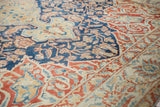 Worn, low-pile texture on a vintage Baktiari rug with indigo and red scrolling floral patterns.