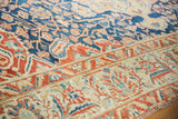 The low pile of a vintage Baktiari carpet's sand and red floral border beside the indigo field.