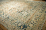 Distressed vintage Khorassan rug texture with terracotta field and blue palmette border.