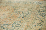 Distressed vintage Khorassan rug's textured pile, showing faded terracotta and teal blossoms.