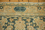 Distressed Khorassan carpet close-up: signature cartouche, dusty terracotta and teal border design, even wear.