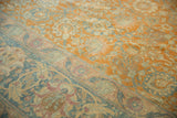 Distressed vintage Tabriz carpet showing worn pile, terracotta palmettes, and dusty blue border details.