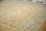 Angled view of a distressed Tabriz carpet showcasing its time-softened rust and blue palmette design.