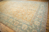A broad view of the vintage Tabriz carpet's expansive terracotta field and dusty sky blue border.