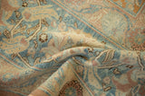A soft fold reveals the low-pile texture and palmette details of this vintage Tabriz carpet.