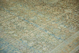 Distressed Tabriz carpet detail, intricate vines, blossoms, muted blues, and faint foundation.