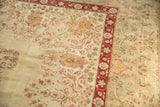 Kerman carpet corner: dusty cochineal red Safavid floral border and distressed ivory field.