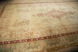 Distressed Kerman carpet showing worn pile, faded ivory field, dusty red floral overlays.