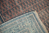 Distressed Serbend carpet pile with faded aubergine and navy boteh, revealing foundation and border reverse.