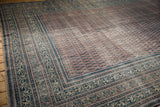 Distressed antique Serbend carpet corner, faded aubergine field, visible foundation, blue border.