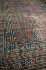 Antique Serbend carpet, faded aubergine and navy boteh pattern with visible foundation.