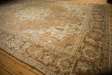 Corner view of a vintage Heriz carpet showing the worn texture and turtle samovar design border.