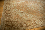 Worn texture of the turtle samovar border motif on a vintage distressed Heriz carpet in sand and coffee brown.