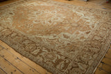 Angled view of a distressed Heriz carpet highlighting its time-softened texture and neutral tones.