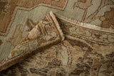 A folded corner shows the even wear and hand-knotted foundation of the vintage Heriz carpet.