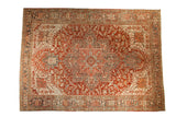 Distressed vintage Heriz carpet with a concentric medallion in cherry red, slate blue, and sand tones.
