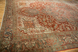 Geometric turtle samovar motifs in the slate blue border of a distressed vintage Heriz carpet.