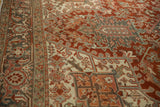 Interconnected turtle and vine border in slate blue and red on a vintage Heriz carpet.
