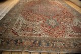 Low perspective view of a vintage Heriz carpet, emphasizing the distressed texture and vast geometric field.