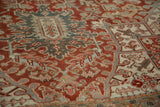 Low-pile texture on a vintage Heriz carpet with geometric turtle motifs in red and blue.