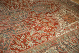 Low pile texture of a vintage Heriz carpet with cherry red, slate blue, and ivory geometric motifs.