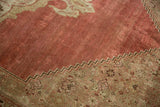 Distressed antique Bijar carpet with pale faded cochineal red field and beige Herati spandrel.