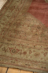 Distressed antique Bijar rug with faded Herati pattern in dusty rose and pale beige, showing wear.
