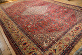 Corner of antique Mahal carpet: sand Herati border, brick red field with blue plant motifs.