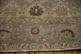 Distressed Tabriz rug fringe and edge with muted slate blue, beige floral design.