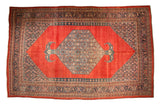 Antique Persian Bijar carpet with a hexagonal medallion and bat-shaped finials on a madder red abrashed field.