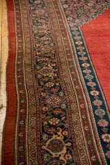 Angled view of the antique Bijar carpet's border with Samovar Turtle motifs in navy and red.