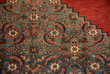 Stepped corner spandrel with Herati motifs in dusty teal against a madder root red field.