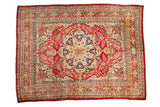 Antique Kerman carpet with a starburst medallion, a cochineal red floral field, and a lotus design border.