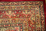 Corner view of an antique Kerman carpet highlighting the germinating lotus flower motifs in the border.