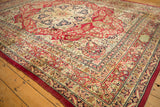 Signature cartouche within the lotus flower border of an antique Persian Kerman carpet.
