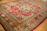 Full perspective of an antique Kerman carpet featuring its starburst medallion and elaborate floral borders.
