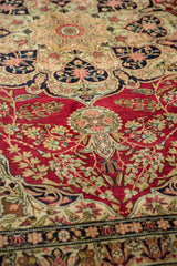 Intricate floral sprays on the hand-knotted, cochineal red pile of an antique Persian Kerman carpet.