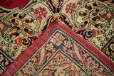 Corner of an antique Kerman carpet folded to show the floral pile and hand-knotted foundation.