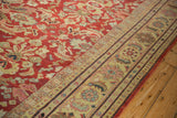 Stylized Herati motifs on the saffron border of a distressed cherry red vintage Mahal carpet.