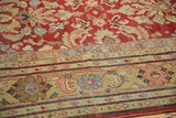 Stylized Herati border in saffron yellow, blue, and rose on a distressed vintage Mahal rug.