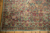 Worn pile texture on the Kerman carpet's thousand flower border in dusty blue and red hues.