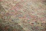 Angled view of the distressed Kerman carpet's time-softened pile and floral pattern.
